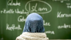 Eine Schülerin mit Kopftuch sitzt an der Johann Hinrich Wichern-Schule in Frankfurt am Main  bei einer Unterrichtsstunde zum Thema Islam vor einer Tafel. Foto:  