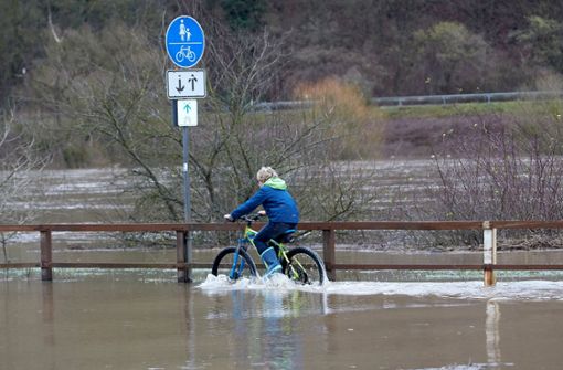 Die Wasserstände steigen. Bei Moselkern in Rheinland-Pfalz scheint das diesen Radfahrer nicht vor einer Spritztour abzuhalten. Foto: dpa