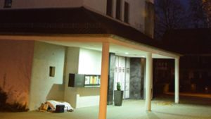 Eine dicke Matratze, ein Federbett mit hellem Bezug und ein kleiner, dunkelblauer Rollkoffer (im Bild links) – das sind die Habseligkeiten der obdachlosen Frau vor der Kirche St. Hedwig. Foto: Alexandra Kratz