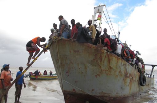 Ein Boot mit etwa 100 Menschen, die aus der überfluteten Region Búzi in Mosambik gerettet wurden, legt am Strand an. Das Schiff hatte zuvor den Hafen von Beira wegen der rauen See nicht erreichen können. Foto: Kate Bartlett/dpa