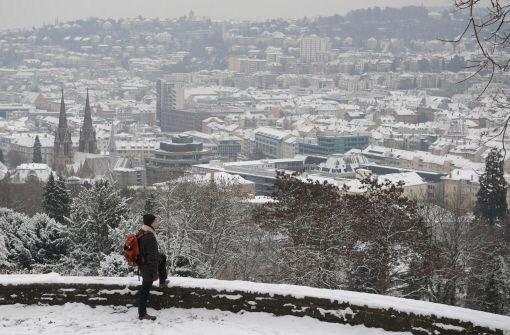 Ein Mann blickt auf das schneebedeckte Stuttgart. Kurz vor dem ersten Adventswochenende sind die Temperaturen gefallen - und mit ihnen die ersten Schneeflocken auch in Stuttgart. Wie Sie sich winterfest machen, erfahren Sie in unserer Bildergalerie. Foto: dpa
