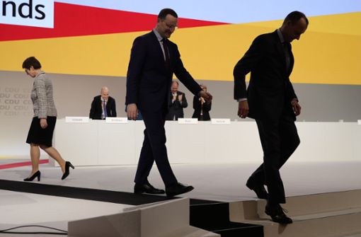 Die bei der Wahl um den CDU-Vorsitz unterlegenen Kandidaten Jens Spahn (M) und Friedrich Merz verlassen beim CDU-Bundesparteitag die Bühne, während die neue CDU-Vorsitzende Annegret Kramp-Karrenbauer zu ihrem Platz geht. Foto: dpa