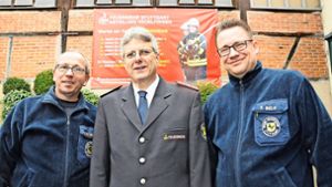 Kommandant Hans Eisele (M.) mit zwei Kollegen vor dem  neuen Werbebanner der Hedelfinger Feuerwehr Foto: Georg Linsenmann