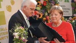 Ein Herz für Tiere: Kretschmann überreicht Merkel ein Bienenhotel als Geschenk. Foto: dpa