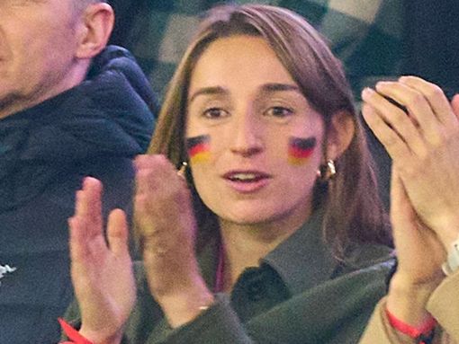 Lena Wurzenberger mit Deutschlandfahne im Gesicht und dem pinken Trikot unter ihrer Jacke beim Spiel gegen die Niederlande. Foto: IMAGO/ActionPictures